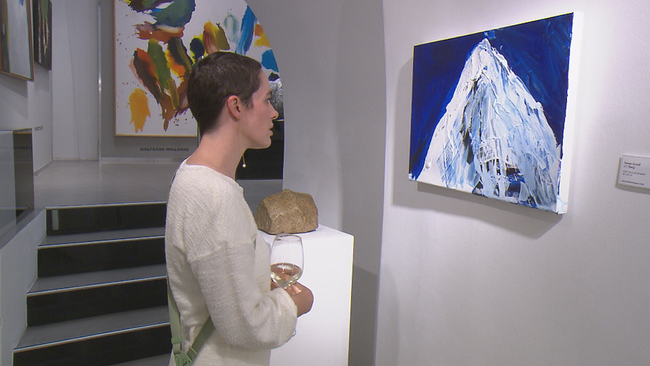 Verena Altenberger im Profil betrachtet intensiv ein blau weißes Bild auf Leinwand