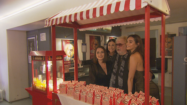 Familie Roncalli unter einem rot-weiß gestreiften Popcorn-Stand 
