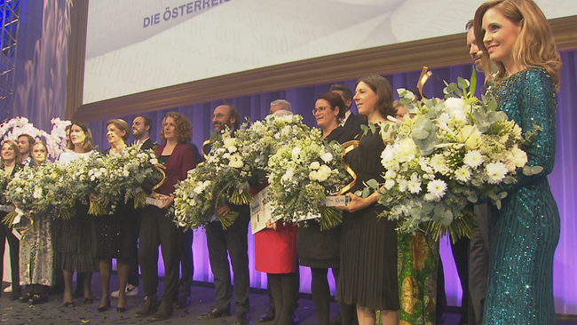 Die nominierten posen in einer Reihe mit pompösen Blumensträußen in die Kamera