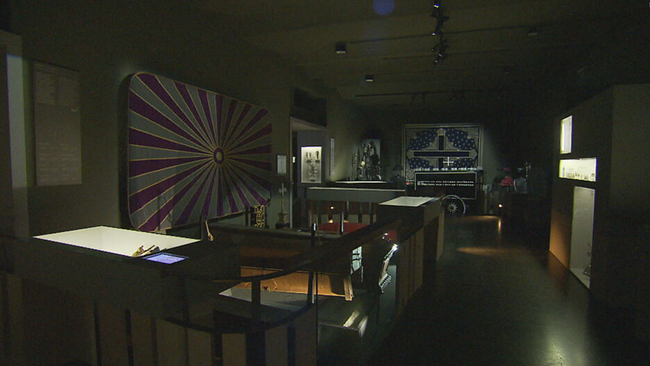 Das Innere des Museums: Ein dunkler Raum, ausgestellte Leichentücher und Artefakte
