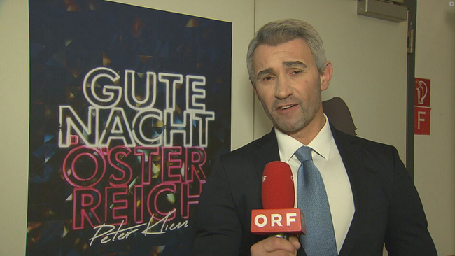 Gernot Kulis in als Nehammer Imitator vor dem Plakat "Gute Nacht Österreich"