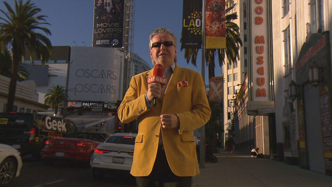 © ORF2/Seitenblicke Reichhold in senfgelbem Sakko und Sonnenbrille moderierend in L.A.