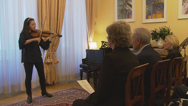 © ORF2/Seitenblicke Violinistin spielt Geige in einem Wohnzimmer, in der ersten Reihe 3 Zuhörer*innen