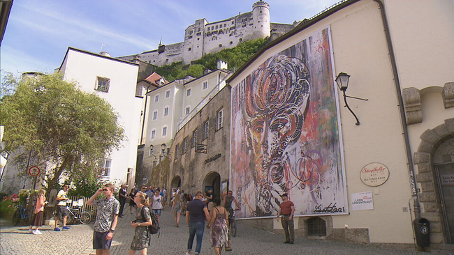 © ORF 2 / Seitenblicke Das Kunstwerk "Lost Horizon" von Leon Löwentraut an der Mauer der Festungsbahn, im Hintergrund die Festung