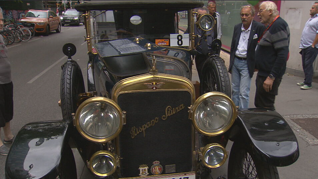 Männer bestaunen einen schwarzen Hispano-Suiza Oldtimer