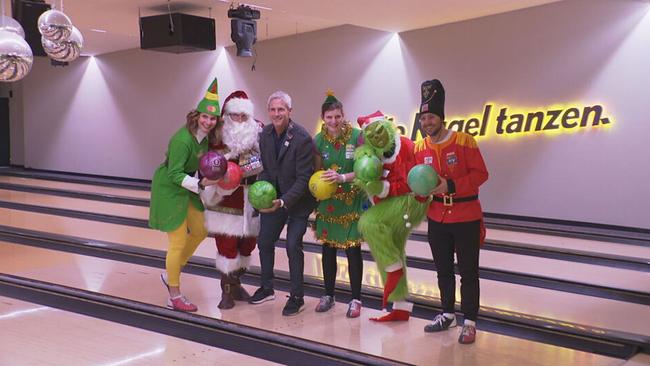 Gruppenbild in Weihnachtskostümen auf der Bowlingbahn