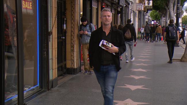 © ORF/Seitenblicke Ein Mann geht über eine Straße, die mit etlichen Sternen verziert ist.