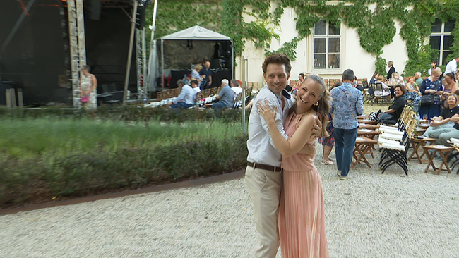 © ORF / Seitenblicke Ein junger Mann und eine junge Frau umarmen sich in einem Park.