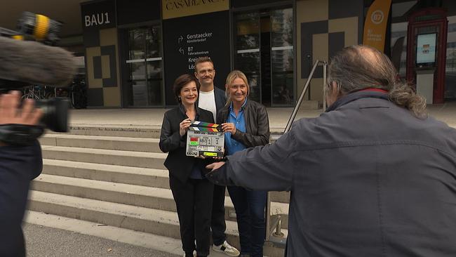 Drei Schauspieler posieren für die Kameras.