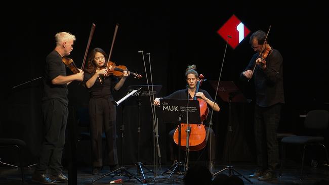 Vier Musiker spielen auf einer Bühne.