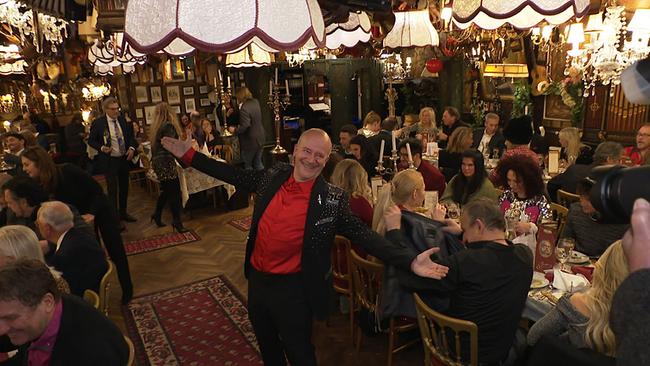 Ein Mann mit Glatze begrüßt seine Gäste in einem Restaurant.