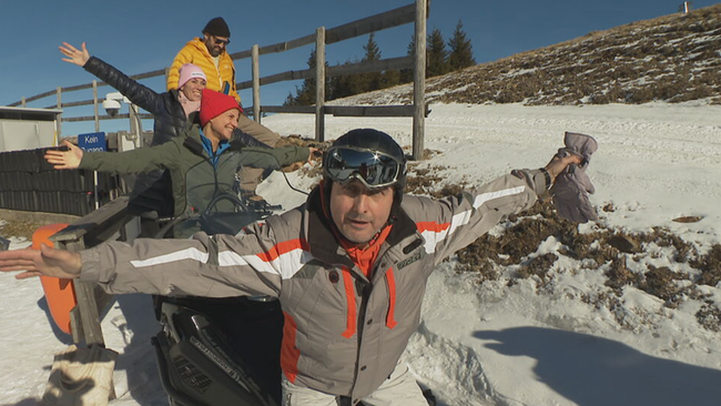 Zwei Männer und zwei Frauen präsentieren sich im Schnee für die Kamera. 