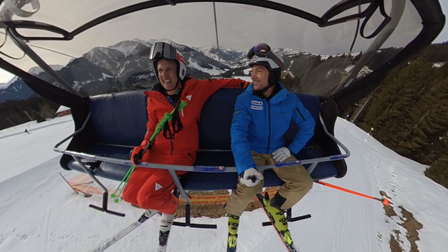 Zwei Männer fahren gemeinsam mit einem Skilift.