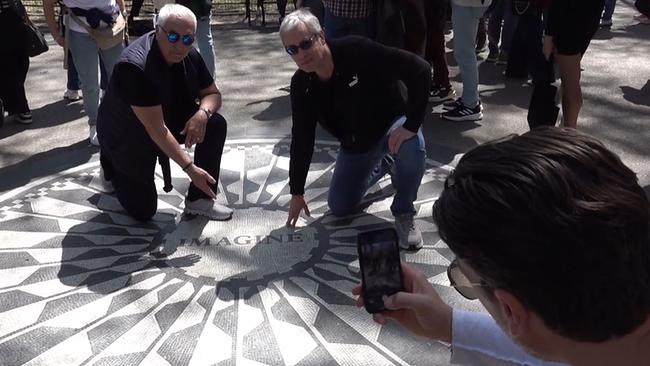 © ORF / Seitenblicke Zwei ältere Männer knien in einem Park auf einer Inschrift.