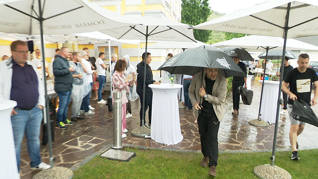 © ORF / Seitenblicke Auf einer verregneten Gartenparty sind Menschen mit Regenschirmen zu sehen...