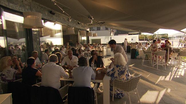 Dutzende Menschen sitzen vor einem Restaurant und Essen