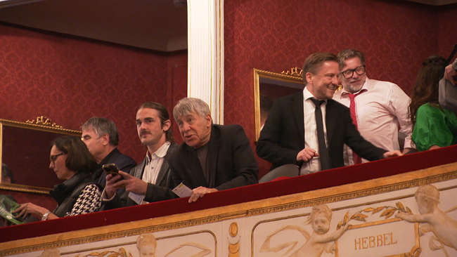 Mehrere Gäste tummeln sich in einer Theaterloge