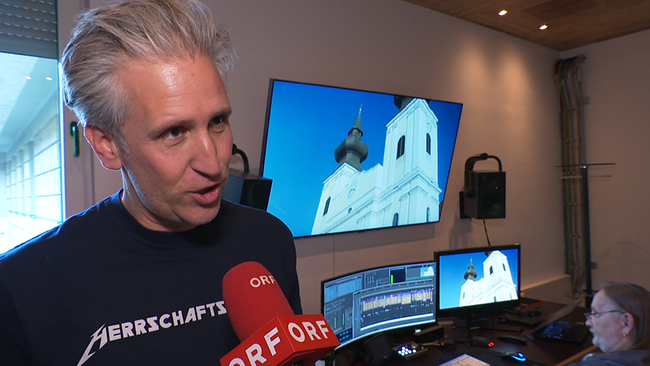 © ORF / Seitenblicke Ein jüngerer Mann wird an einem TV-Schnittplatz interviewt.