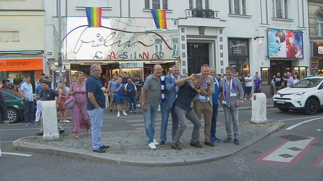 © ORF 2 / Seitenblicke Herbert Prohaska, Toni Pfeffer, Erich Obermeyer und weitere Austria Wien Legenden stehen mit violetten Schals vor dem Film Casino