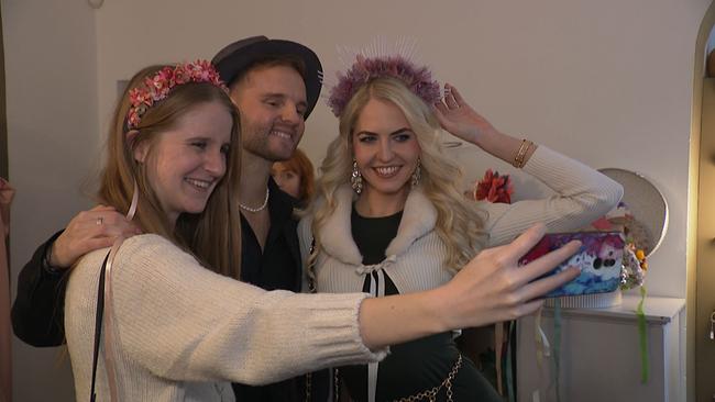 drei BesucherInnen machen ein Selfie mit Hüten auf den Köpfen
