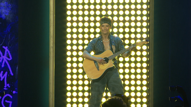 © ORF / Seitenblicke Musical Darsteller Vincent Bueno auf der Bühne mit Gitarre und vor Scheinwerfern