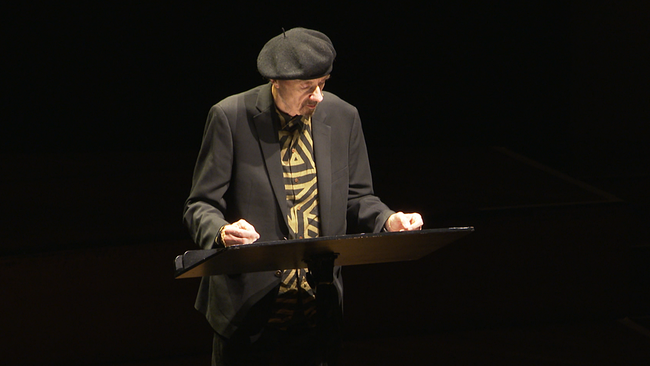 Ein Mann steht auf der Bühne und liest