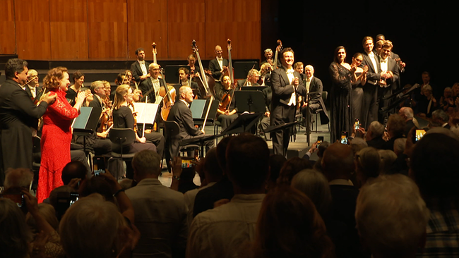 Orchester und Opernsänger:innen auf der Bühne
