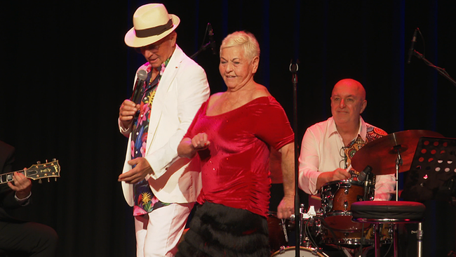 Ein männlicher und eine weibliche Sängerin auf der Bühne. Im Hintergrund ein Schlagzeuger.