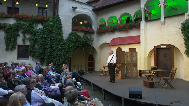 Theaterbühne in einem Innenhof mit Publikum