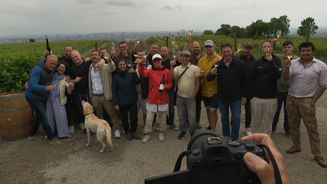 Eine Gruppe von Menschen posieren in den Weinbergen in die Kamera