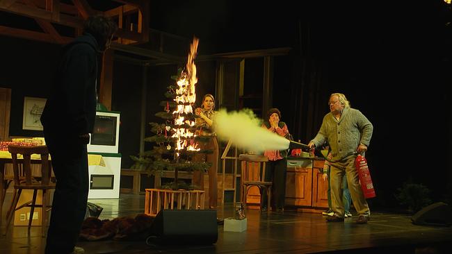 Auf einer Bühne wird ein brennender Christbaum gelöscht...