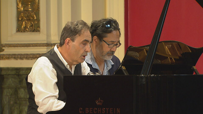 Paul und Rico Gulda sitzen am Flügel der Friedrich Gulda School of Music und spielen Klavier