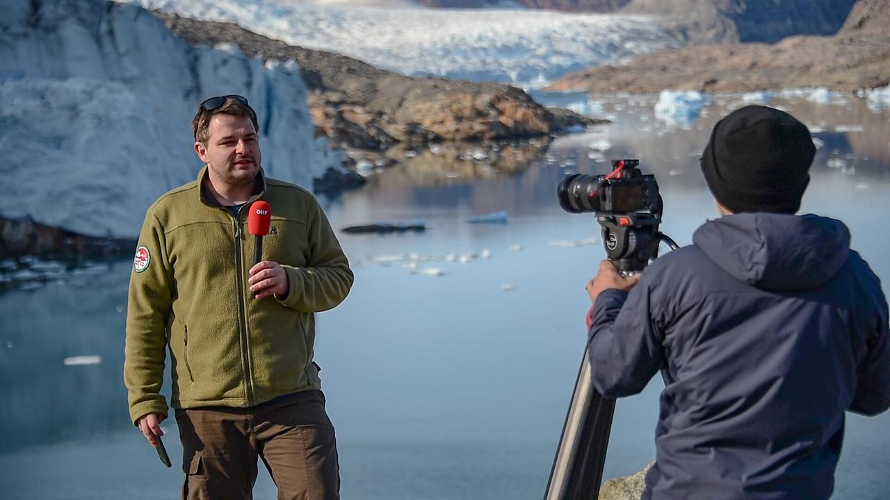 © ORF/Christoph Ruhsam Paul Sihorsch in Grönland berichtet vor einer Gletscherlandschaft in eine Kamera.