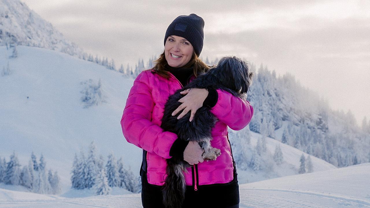 © ORF Barbara Karlich mit Meixi im Arm auf der schneebedeckten Zwieselalm