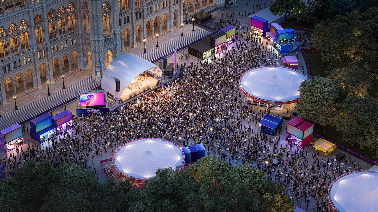 © ZOOMVP/Stadt Wien Marketing Eine große Menschenmenge feiert vor einer beleuchteten Bühne auf dem Rathausplatz vor dem Wiener Rathaus.