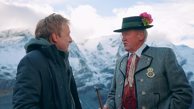 © ORF/Alpha Vision Film Max Müller im Gespräch mit Bergführer Peter Suntinger vor einer verschneiten Alpenkulisse.