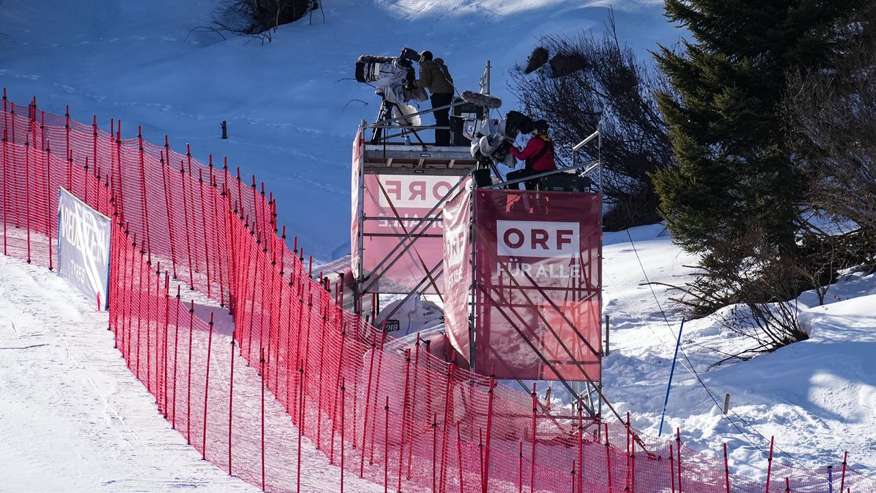 © ORF/Roman Zach-Kiesling Zwei Kameramänner auf jeweils einem Gerüstturm mit ORF-Logo entlang einer Skipiste