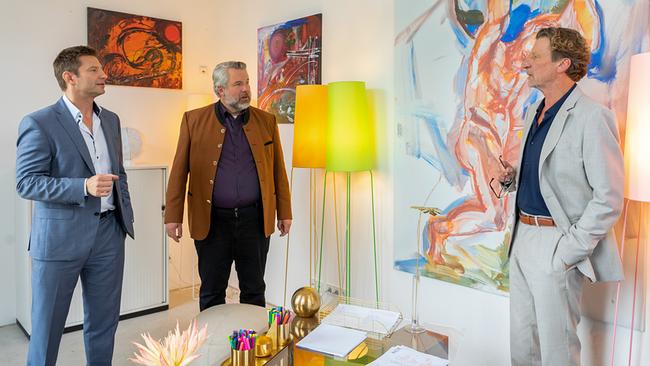 Professor Leonhard Bülow berichtet den Kommissaren  Hansen und Stadler von der Zusammenarbeit mit dem ermordeten Kollegen in einem hellen, kunstvoll eingerichteten Büro vor großen abstrakten Gemälden.