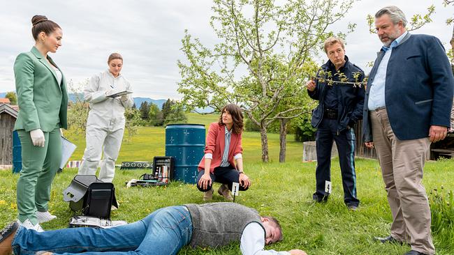 © ORF/ZDF/Linda Gschwentner An einem ländlichen Tatort untersuchen Pathologin Ela Atay und die Spurensicherin eine Leiche in der Wiese. Die Kommissare Andresen, Stadler und Polizeihauptmeister Mohr stehen daneben.