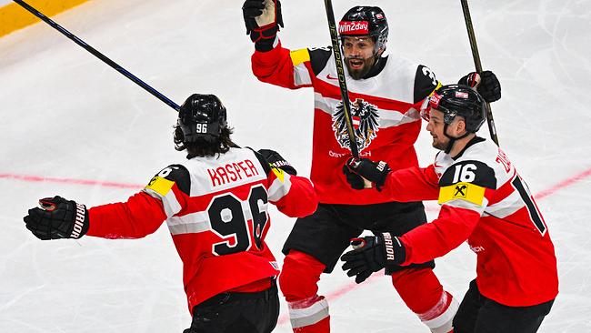 Österreichs Stürmer Nr. 96 Marco Kasper feiert mit Österreichs Stürmer Nr. 03 Peter Schneider und Österreichs Stürmer Nr. 16 Dominic Zwerger nach dem 2:0 während des IIHF-Eishockey-Weltmeisterschaftsspiels der Männer zwischen Österreich und der Slowakei am 12. Mai 2025 in Stockholm.