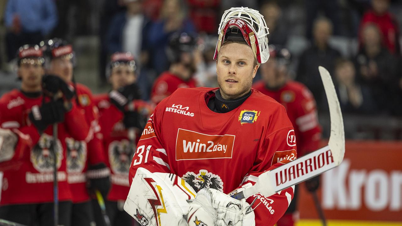 Alte Voltanen (AUT)  in roter Ausrüstung steht mit Fanghandschuh und Schläger auf dem Eis, während sein Team im Hintergrund aufgereiht ist - anlässlich des Eishockey-Testspiels zwischen Österreich und Slowenien in Klagenfurt.