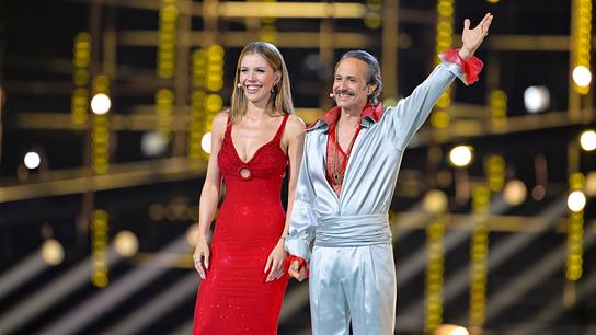 Victoria Swarovski in roter Abendrobe und Michael Ostrowski in weißem Satinanzug und rotem Spitzenhemd auf der ESC-Bühne bei den Proben für das Semifinale 1 des Eurovision Song Contest 2026