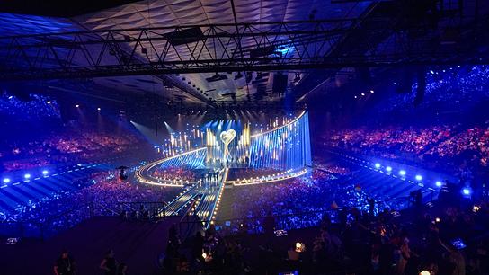 Ansicht der riesigen, beleuchteten Showbühne in einer ausverkauften Wiener Stadthalle mit tausenden Zuschauerinnen und Zuschauern und spektakulärer Lichtinszenierung beim ESC-Semifnale 2.