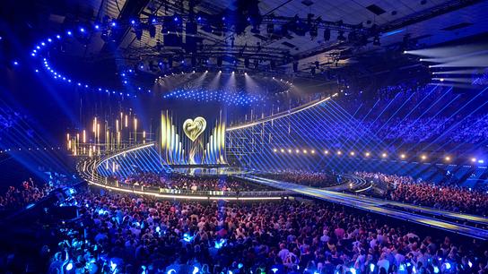 Ansicht der riesigen, beleuchteten Showbühne in einer ausverkauften Wiener Stadthalle mit tausenden Zuschauerinnen und Zuschauern und spektakulärer Lichtinszenierung beim ESC-Semifnale 2.