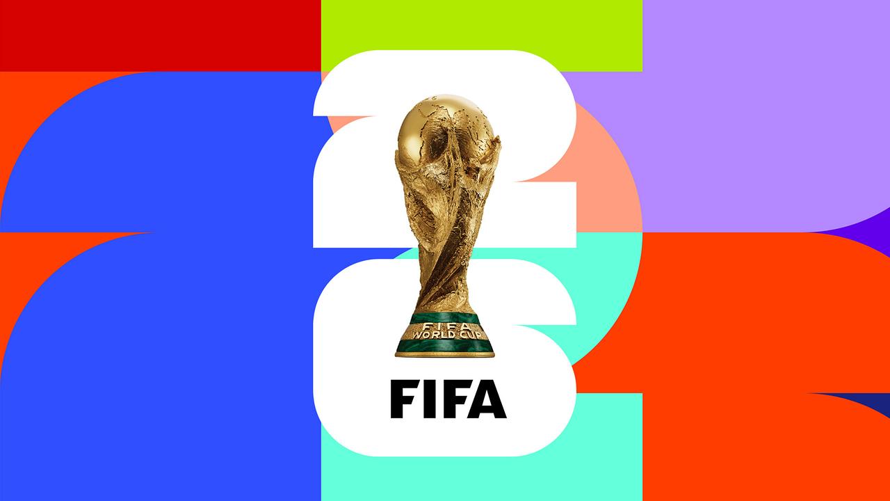 Der FIFA‑Fußball-WM‑Pokal ist vor einer bunten, grafischen Farbflächen‑Komposition platziert, über einer großen weißen „26“ mit dem Schriftzug „FIFA“.