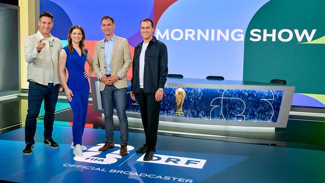 © ORF/Thomas Ramstorfer Helge Payer, Kristina Inhof, Christian Diendorfer und Michael Liendl stehen in einem Fußball-WM‑Studio vor einem „Morning Show“-Set mit Fußball‑Branding und einer Trophäe im Hintergrund.