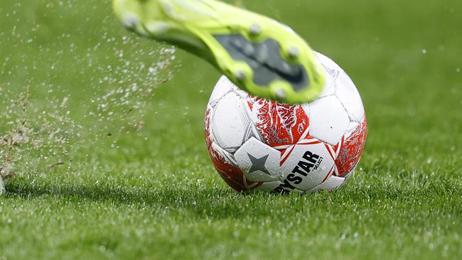 Ein Fußballer mit gelber Hose und gelben Stutzen schießt den Ball auf regennassem Rasen während der Admiral Bundesliga- Begegnung / Qualifikationsrunde / 1. Runde zwischen GAK und WSG Tirol am Samstag, 29. März 2025, in der Merkur Arena in Graz.