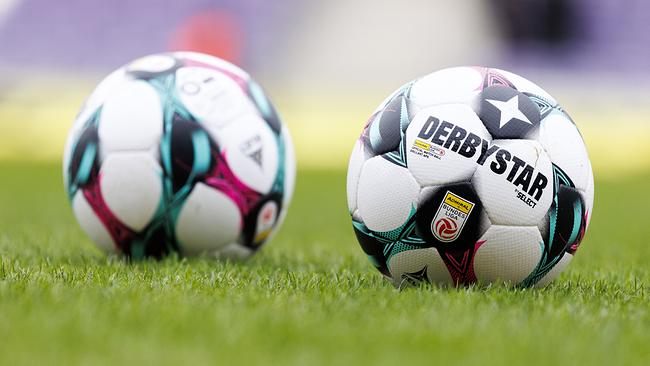Zwei offizielle Fußballbälle liegen auf dem grünen Rasen eines Spielfelds, einer davon mit gut sichtbarem „Derbystar“-Logo anl. einer Fußball-Bundesliga-Begegnung zwischen FK Austria Wien und SK Rapid in der Generali Arena in Wien.