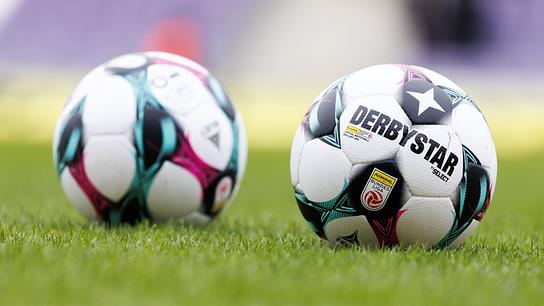 Zwei offizielle Fußballbälle liegen auf dem grünen Rasen eines Spielfelds, einer davon mit gut sichtbarem „Derbystar“-Logo anl. einer Fußball-Bundesliga-Begegnung zwischen FK Austria Wien und SK Rapid in der Generali Arena in Wien.