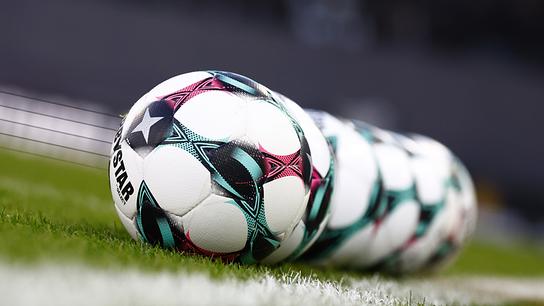 Fußbälle der Marke "Derbystar" liegen aufgereiht neben der Seitenlinie am grünen Rasen aufgenommen am Sonntag, 07. Dezember 2025, in Graz.